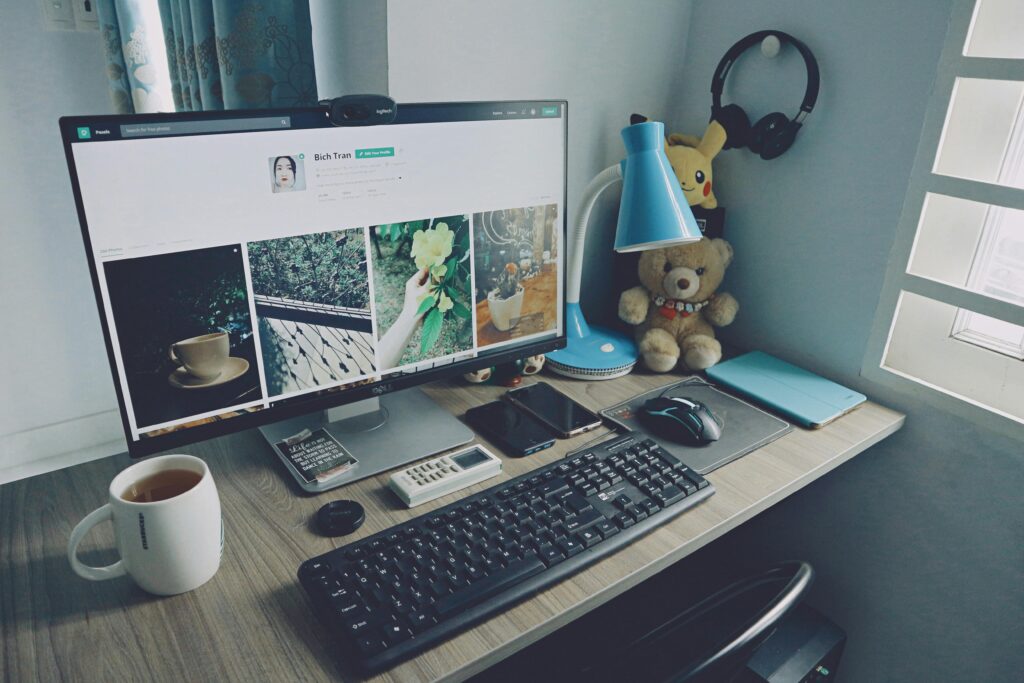 A tidy home office desk setup with a computer, keyboard, and personal items, creating a cozy work atmosphere.